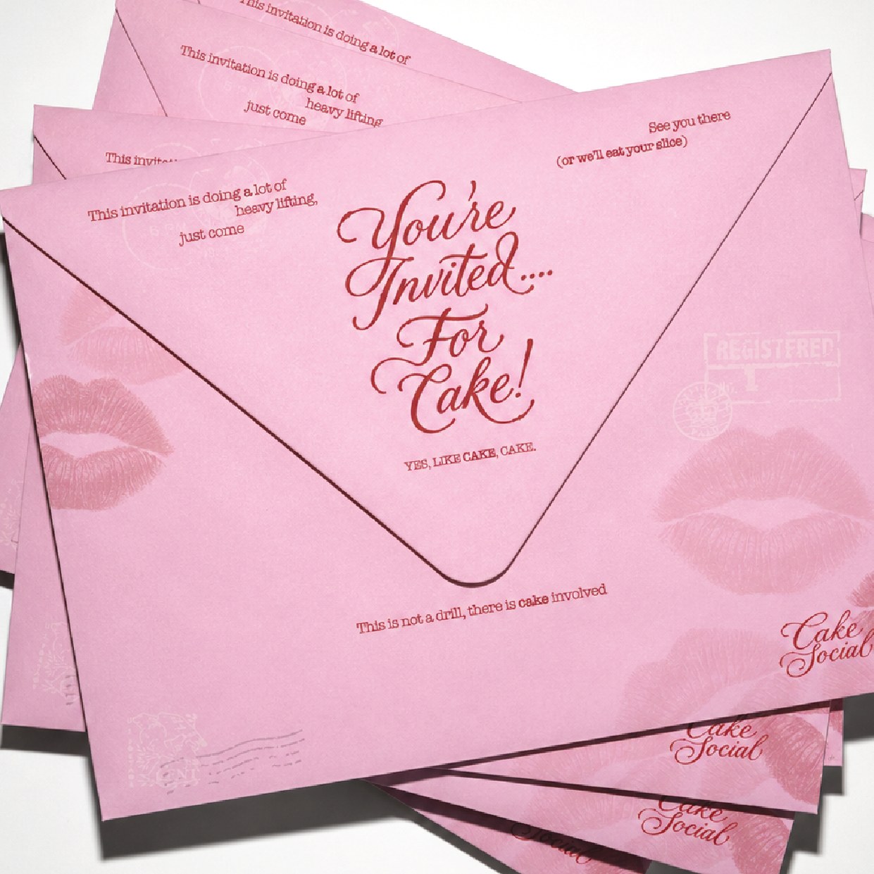 Several Cake Social envelopes fanned in a stack, each showing the lip print and wordmark
