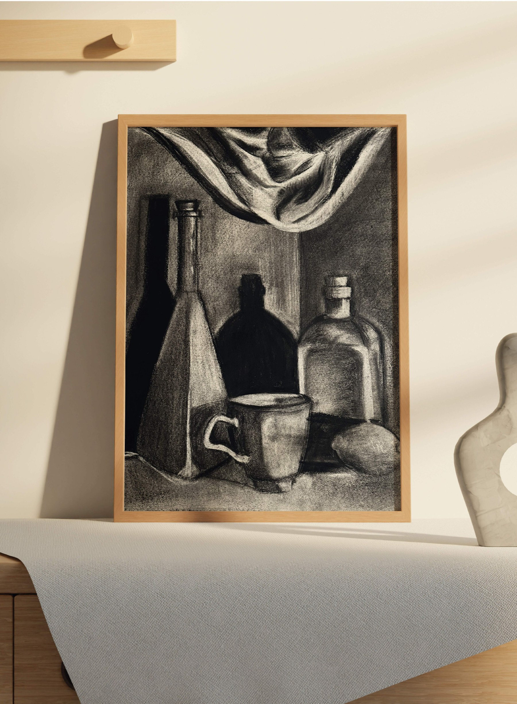 The drapery study in an oak frame, leaning on a sideboard beside a pale ceramic vase