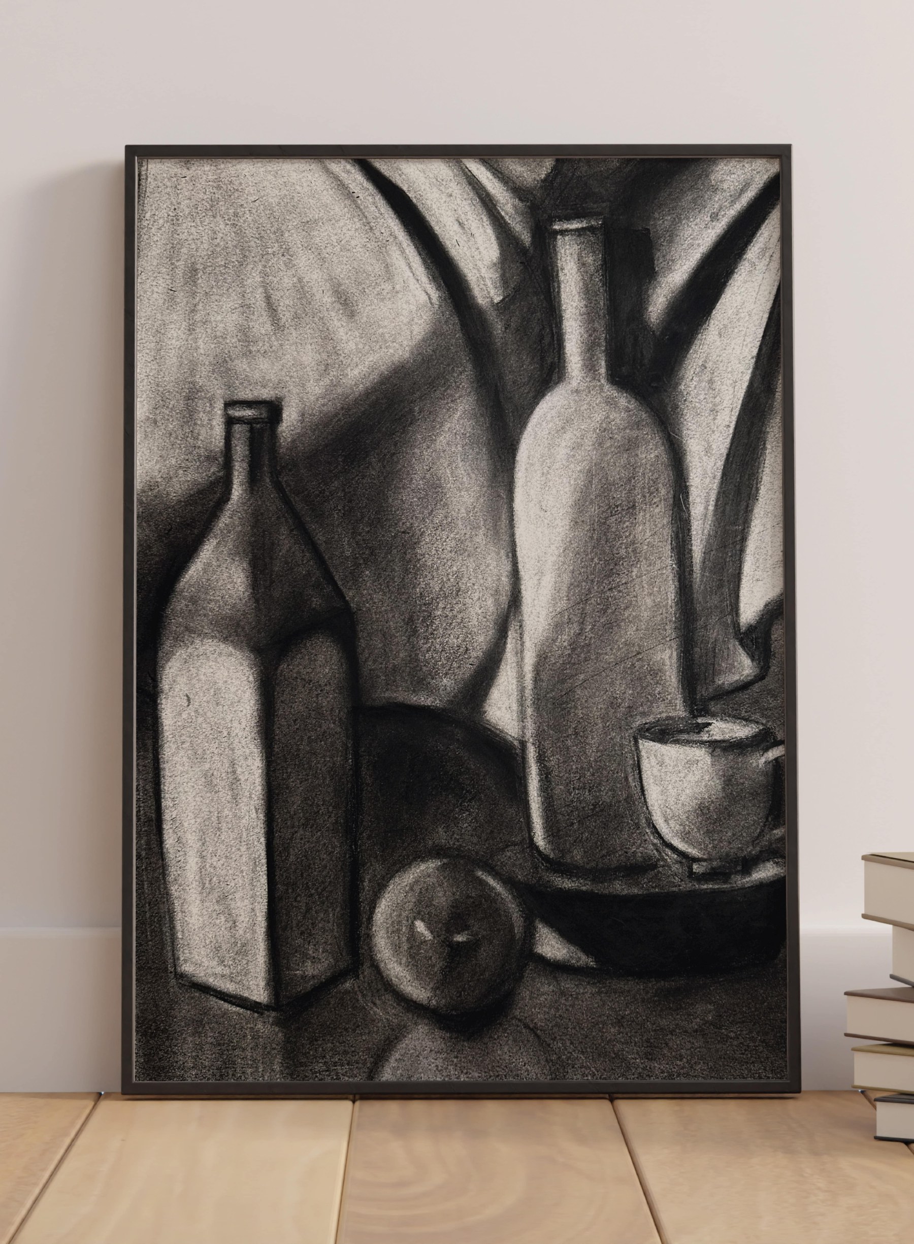The two-bottle study in a black frame, leaning against a wall on a wooden floor beside a stack of books