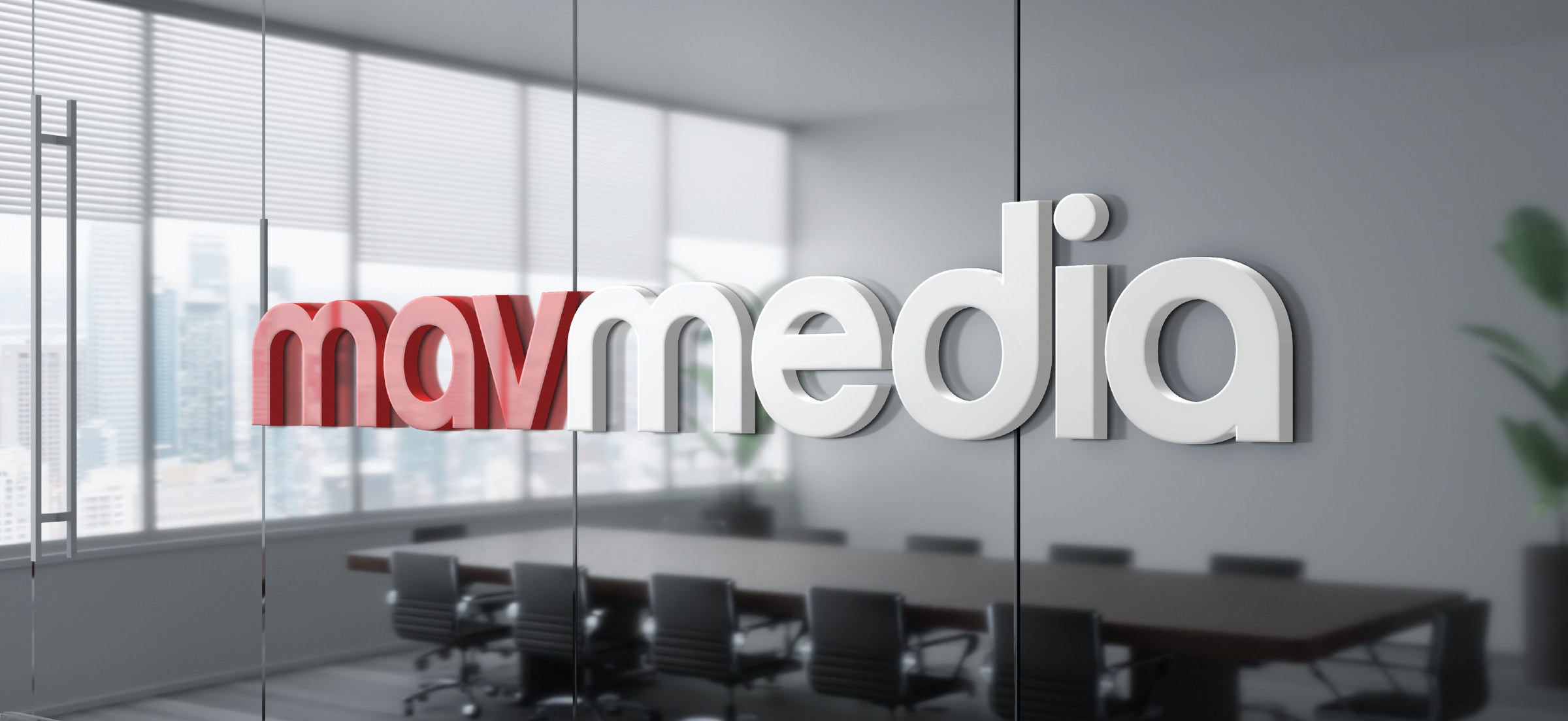 The Mavmedia logo in dimensional letters on a glass office wall, boardroom visible behind